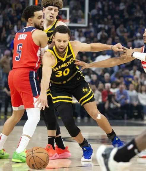 Golden State Warriors guard Stephen Curry (30) dribbles away from pressure by Washington Wizards guard Jordan Poole (13) during the first quarter at Chase Center.