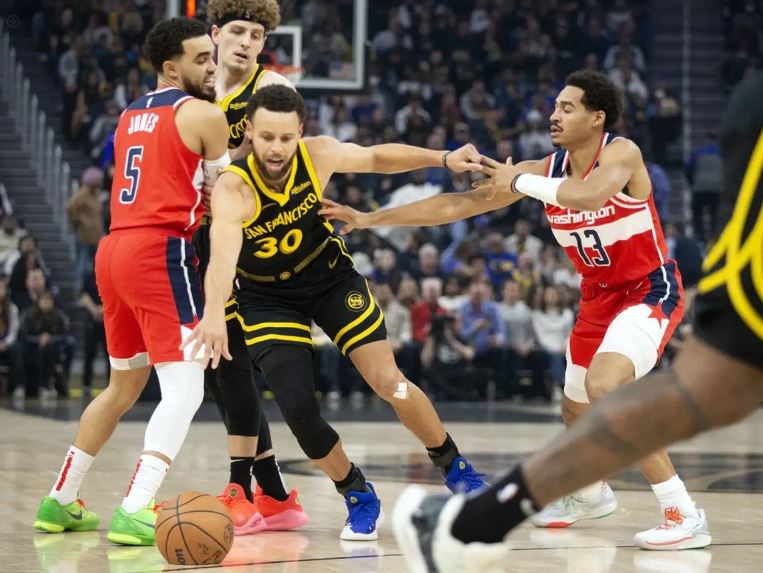 Golden State Warriors guard Stephen Curry (30) dribbles away from pressure by Washington Wizards guard Jordan Poole (13) during the first quarter at Chase Center.